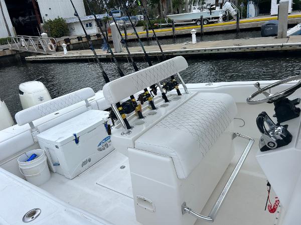 Slide: The Image of 2004 Venture 34 Center Console boat with fishing rods and cooler at dock. - 4