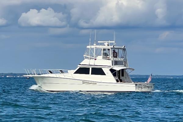 Slide: The Image of 1988 Viking 48 Convertible yacht cruising on open water under cloudy skies. - 0