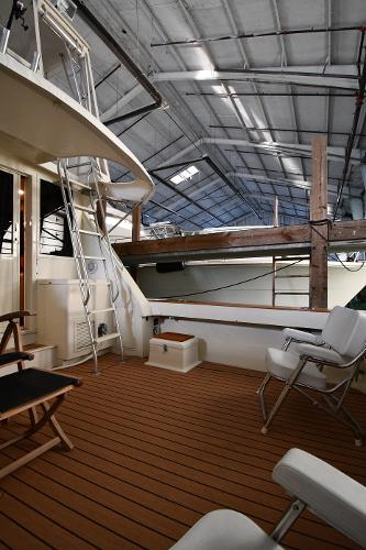 Slide: The Image of 1988 Viking 48 Convertible yacht deck with seating and ladder in a covered marina. - 10