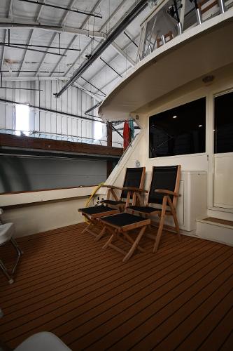 Slide: The Image of 1988 Viking 48 Convertible yacht deck with wooden chairs in a boat shed. - 12