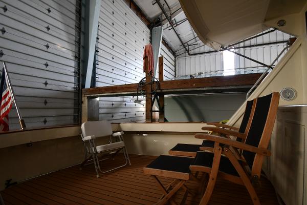 Slide: The Image of 1988 Viking 48 Convertible yacht interior with chairs, docked in a spacious garage. - 13