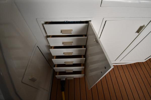 Slide: The Image of Open storage drawers on 1988 Viking 48 Convertible boat with wooden flooring. - 16