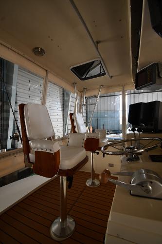 Slide: The Image of 1988 Viking 48 Convertible yacht interior with helm, chairs, and controls. - 36