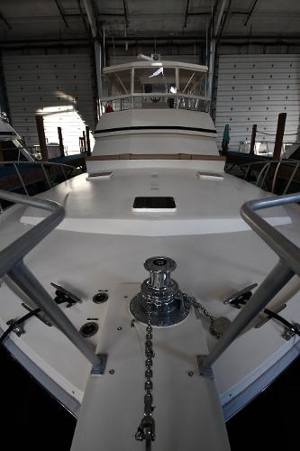 Slide: The Image of 1988 Viking 48 Convertible yacht in a marina, showcasing its sleek deck and anchor chain. - 4
