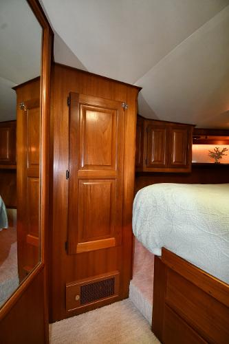 Slide: The Image of 1988 Viking 48 Convertible yacht interior with wooden cabinetry and cozy bedroom. - 48