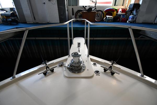 Slide: The Image of Bow of 1988 Viking 48 Convertible yacht in storage, featuring anchor winch and railings. - 5