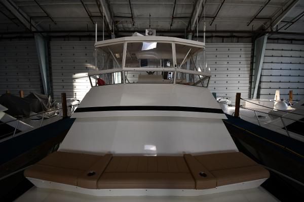 Slide: The Image of 1988 Viking 48 Convertible yacht in storage, front view in dimly lit warehouse. - 6