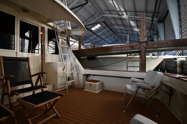Slide: The Image of 1988 Viking 48 Convertible yacht interior with seating and ladder in a boat shed. - 9