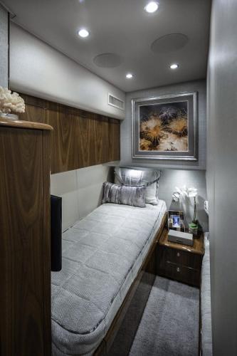 Slide: The Image of 2025 Viking 58 Convertible yacht interior cabin with modern decor and cozy single bed. - 13
