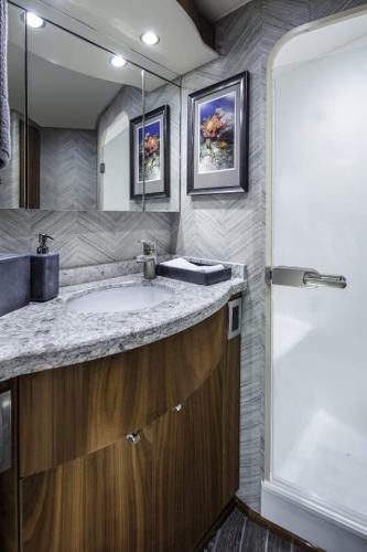 Slide: The Image of Modern bathroom in 2025 Viking 58 Convertible yacht with granite countertop and glass shower. - 15