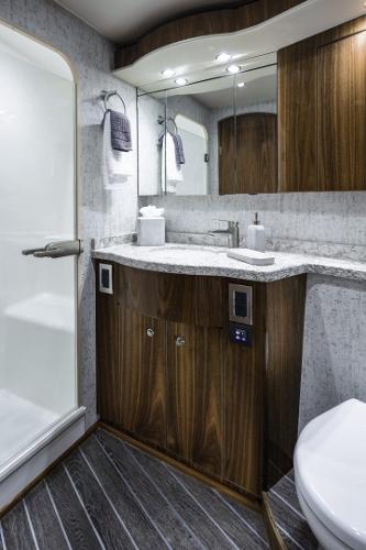 Slide: The Image of Modern bathroom in 2025 Viking 58 Convertible yacht with wood cabinetry and glass shower. - 17