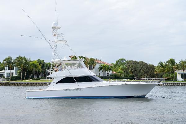 Slide: The Image of 2005 Viking 61 yacht cruising on a calm waterway with lush greenery in the background. - 0