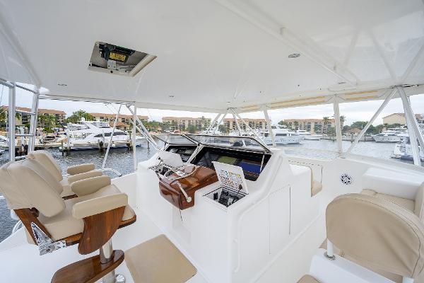 Slide: The Image of 2005 Viking 61 yacht helm with beige seating and marina view. - 10