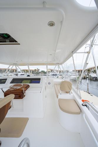 Slide: The Image of 2005 Viking 61 yacht interior with helm, seating, and marina view. - 16