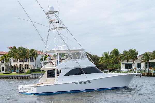Slide: The Image of 2005 Viking 61 yacht cruising near waterfront homes with palm trees. - 6