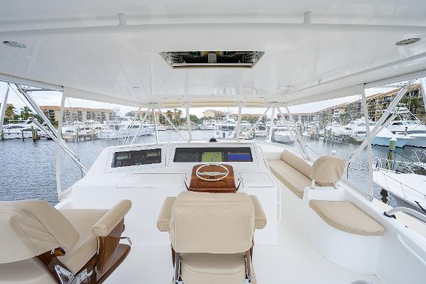 Slide: The Image of Luxurious 2005 Viking 61 yacht interior with helm, beige seating, and marina view. - 8