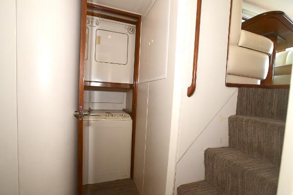 Slide: The Image of Laundry area with stacked washer and dryer in 2000 Viking 65 Convertible yacht. - 23