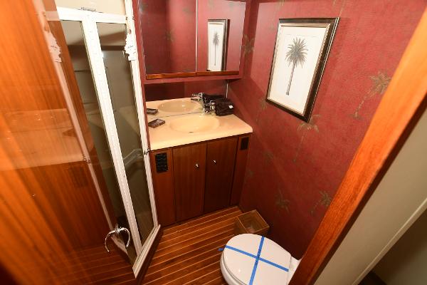 Slide: The Image of Bathroom interior of a 2000 Viking 65 Convertible yacht with wooden cabinetry and palm tree decor. - 25