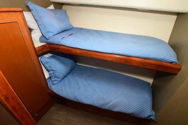 Slide: The Image of Bunk beds with blue bedding in a 2000 Viking 65 Convertible yacht. - 26