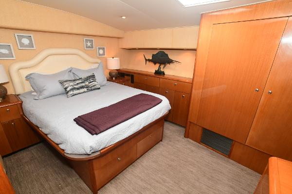 Slide: The Image of Luxurious bedroom interior of 2000 Viking 65 Convertible yacht with wooden cabinetry. - 28