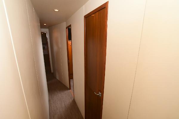 Slide: The Image of Narrow hallway inside 2000 Viking 65 Convertible yacht with wooden door. - 31