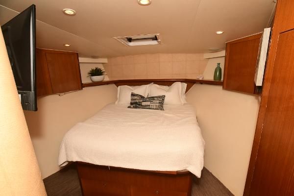 Slide: The Image of Cozy bedroom in a 2000 Viking 65 Convertible yacht with wooden cabinets and modern decor. - 32