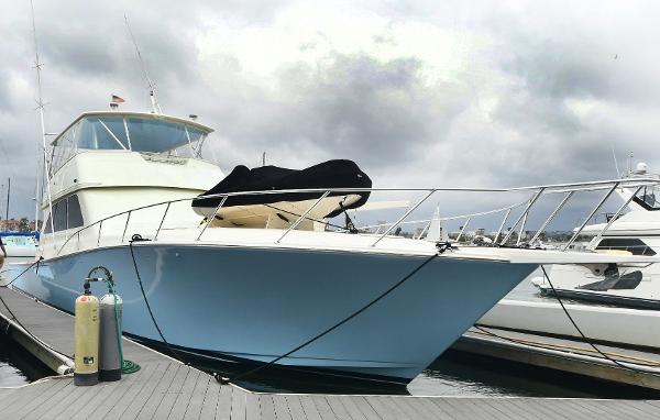 Slide: The Image of 2000 Viking 65 Convertible yacht docked at marina under cloudy sky. - 8