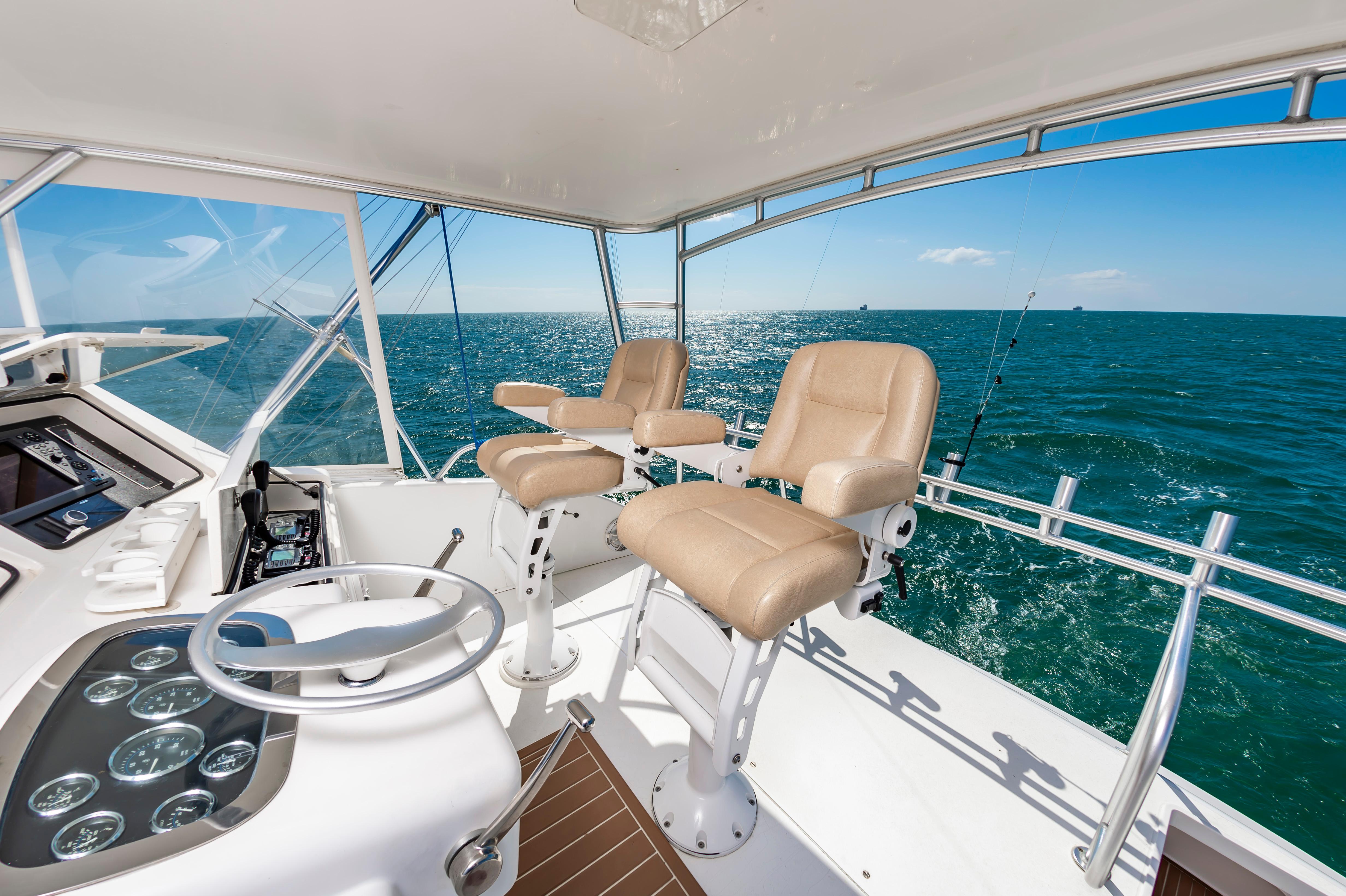 Slide: The Image of 1998 Viking Convertible yacht helm with ocean view and beige captain chairs. - 21
