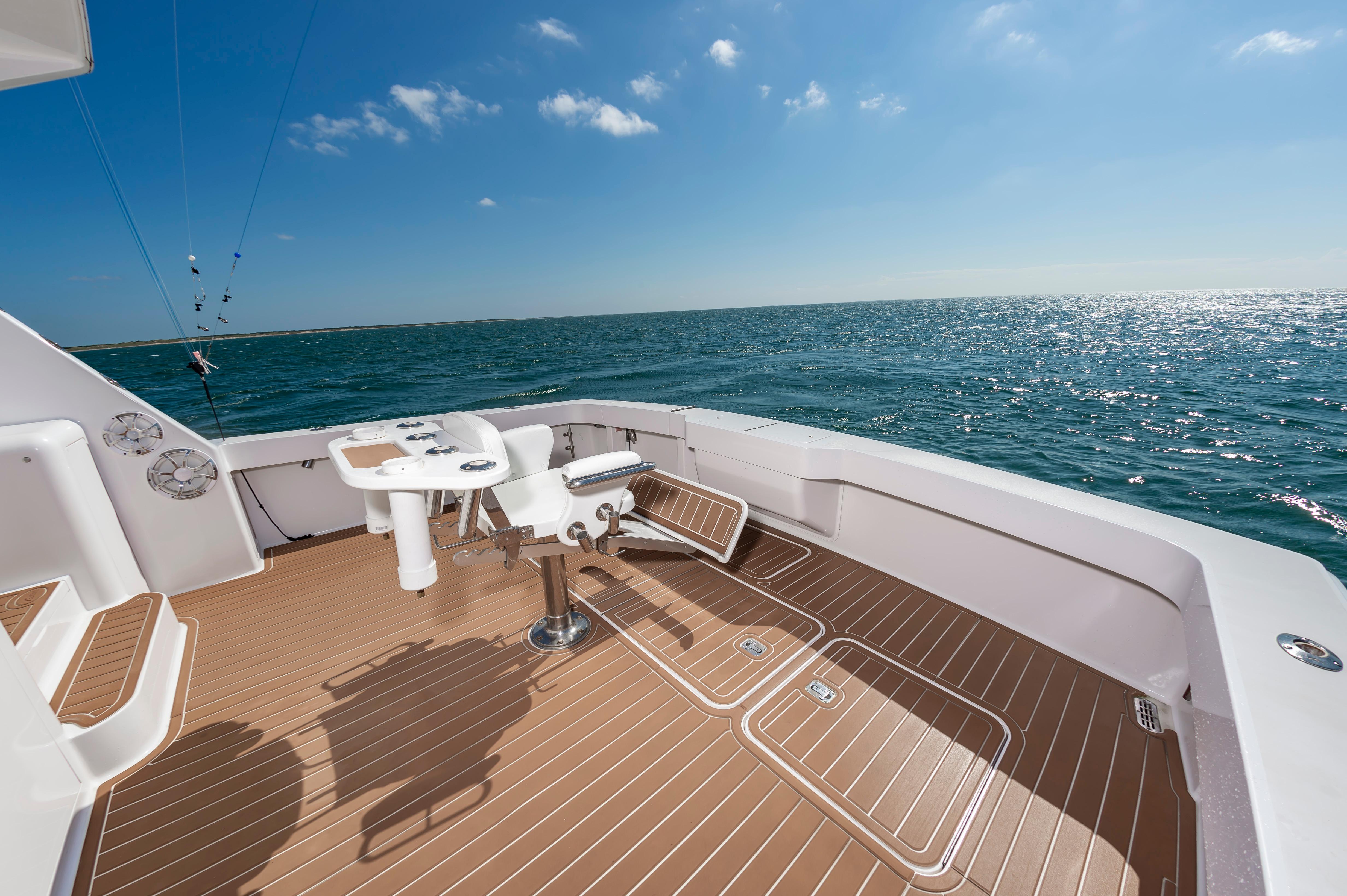 Slide: The Image of 1998 Viking Convertible yacht deck with fishing chair, ocean view, and clear blue sky. - 23