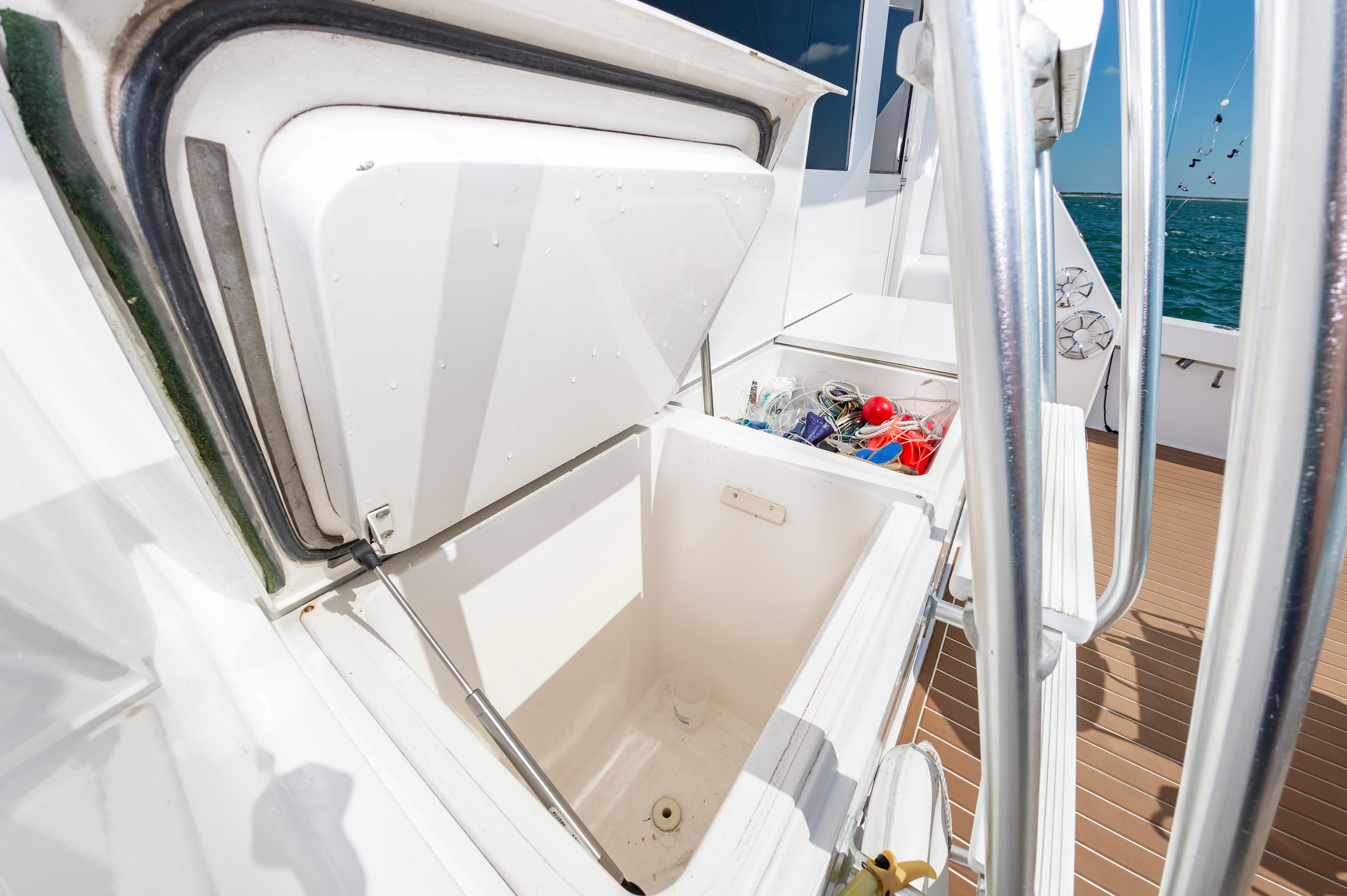 Slide: The Image of Open storage compartment on a 1998 Viking Convertible boat with fishing gear. - 26