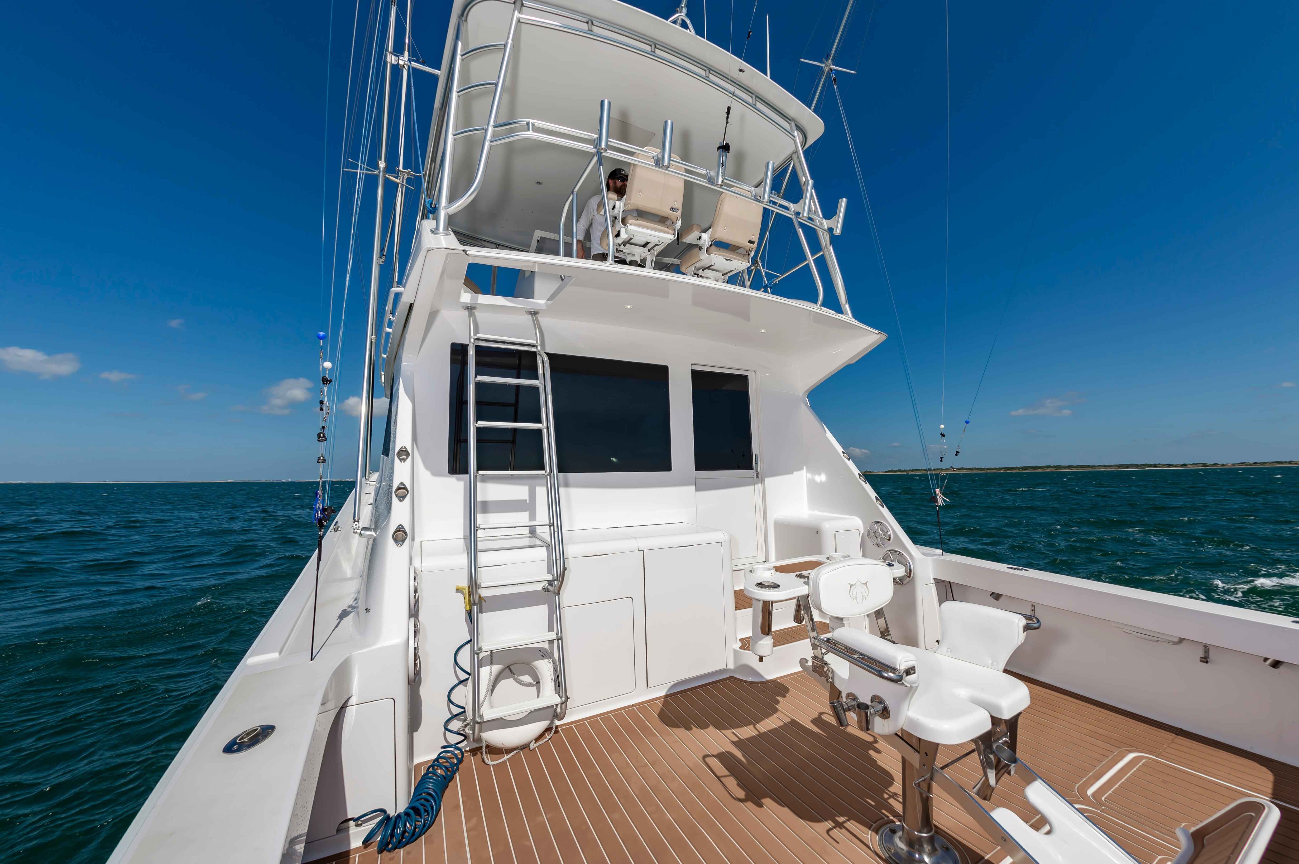 Slide: The Image of 1998 Viking Convertible yacht on open water, featuring fishing chairs and upper deck. - 28