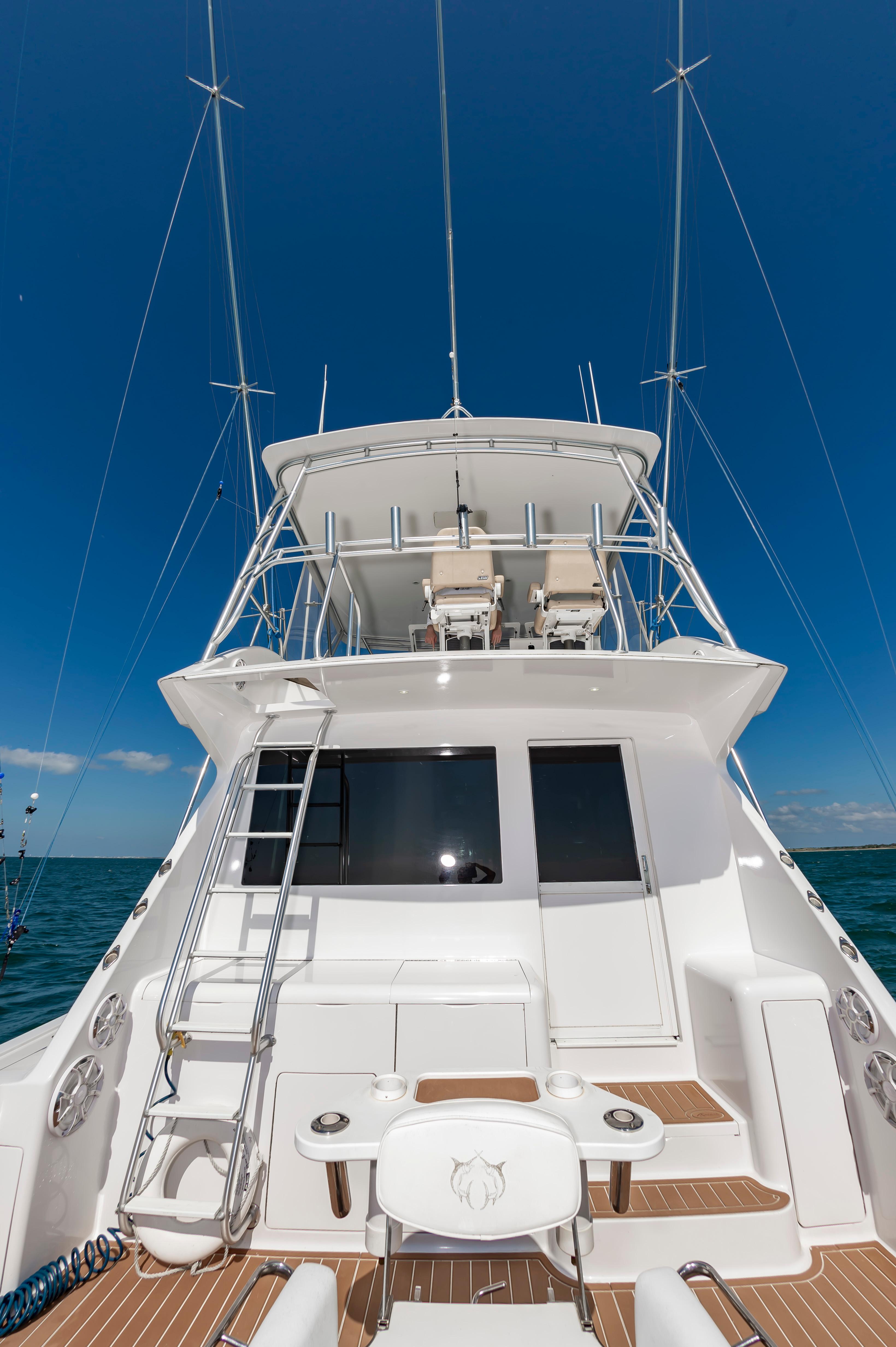 Slide: The Image of 1998 Viking Convertible yacht with fishing gear and ladder, under clear blue sky. - 29