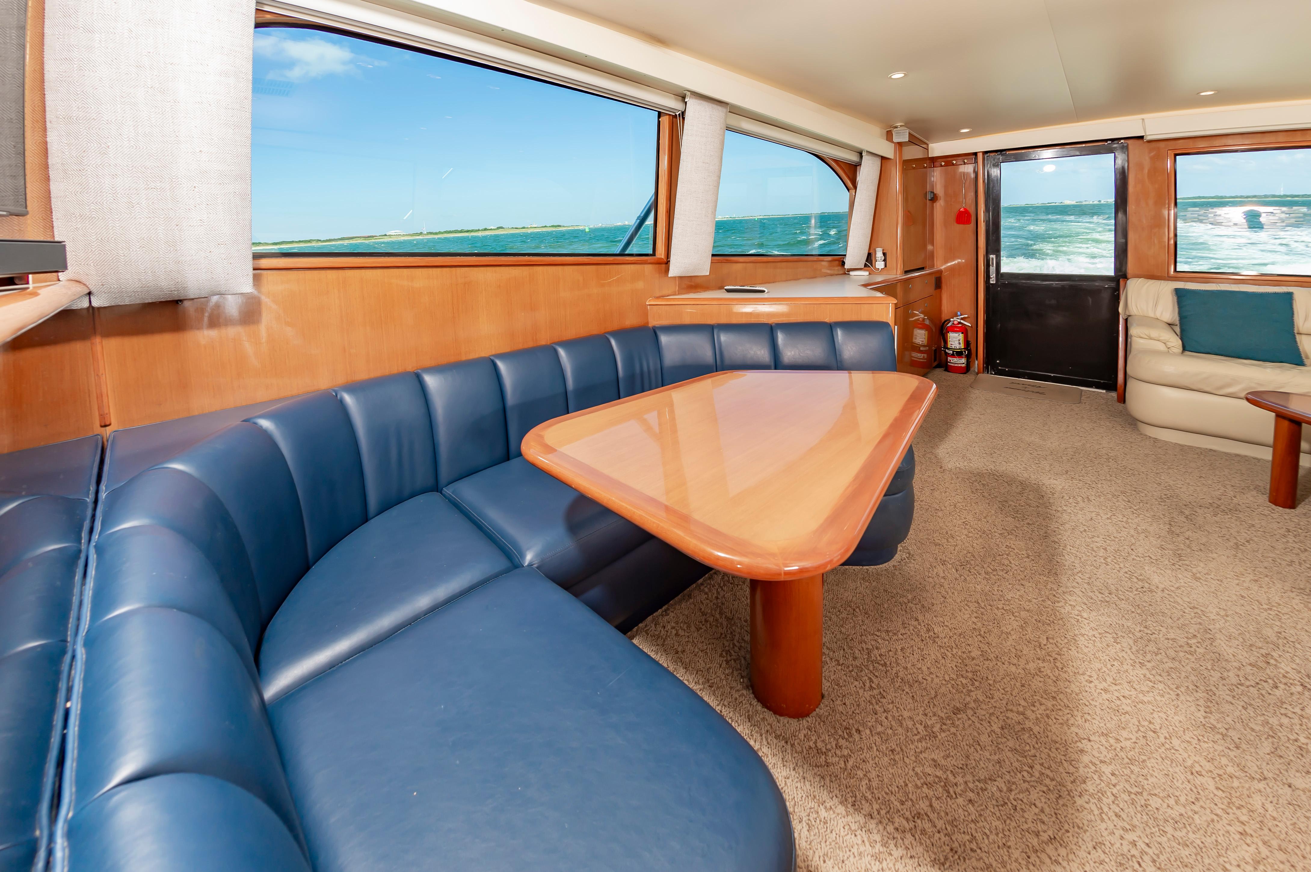 Slide: The Image of Interior of 1998 Viking Convertible yacht with blue leather seating and ocean view. - 36
