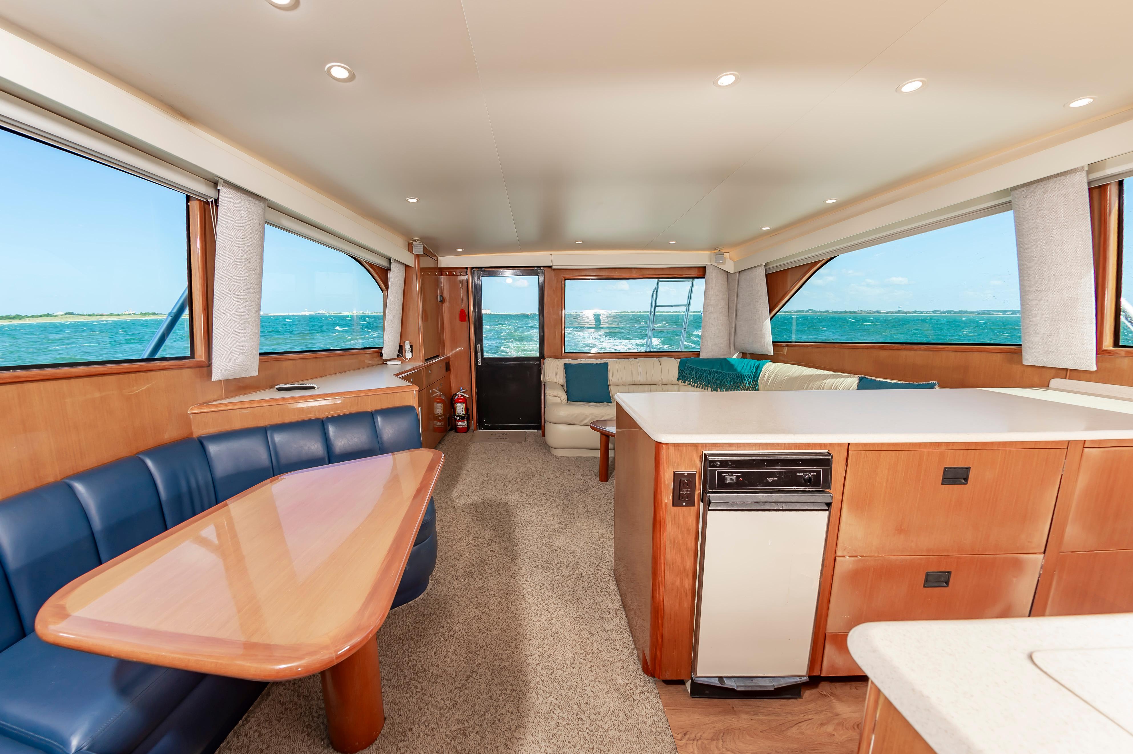 Slide: The Image of Interior of 1998 Viking Convertible yacht with ocean view, featuring dining area and lounge. - 37