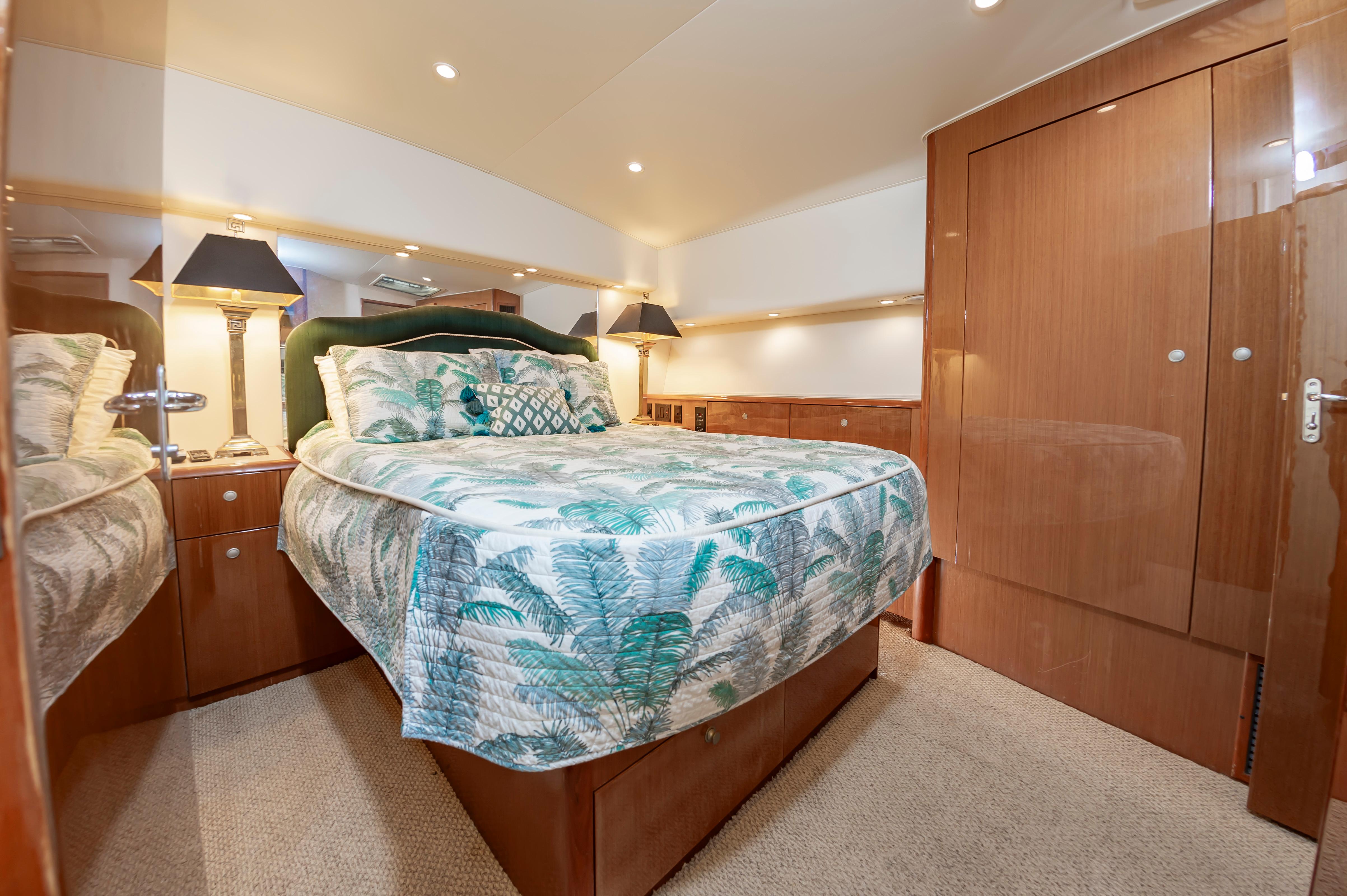 Slide: The Image of Luxurious bedroom interior of a 1998 Viking Convertible yacht with elegant bedding and wooden cabinetry. - 43
