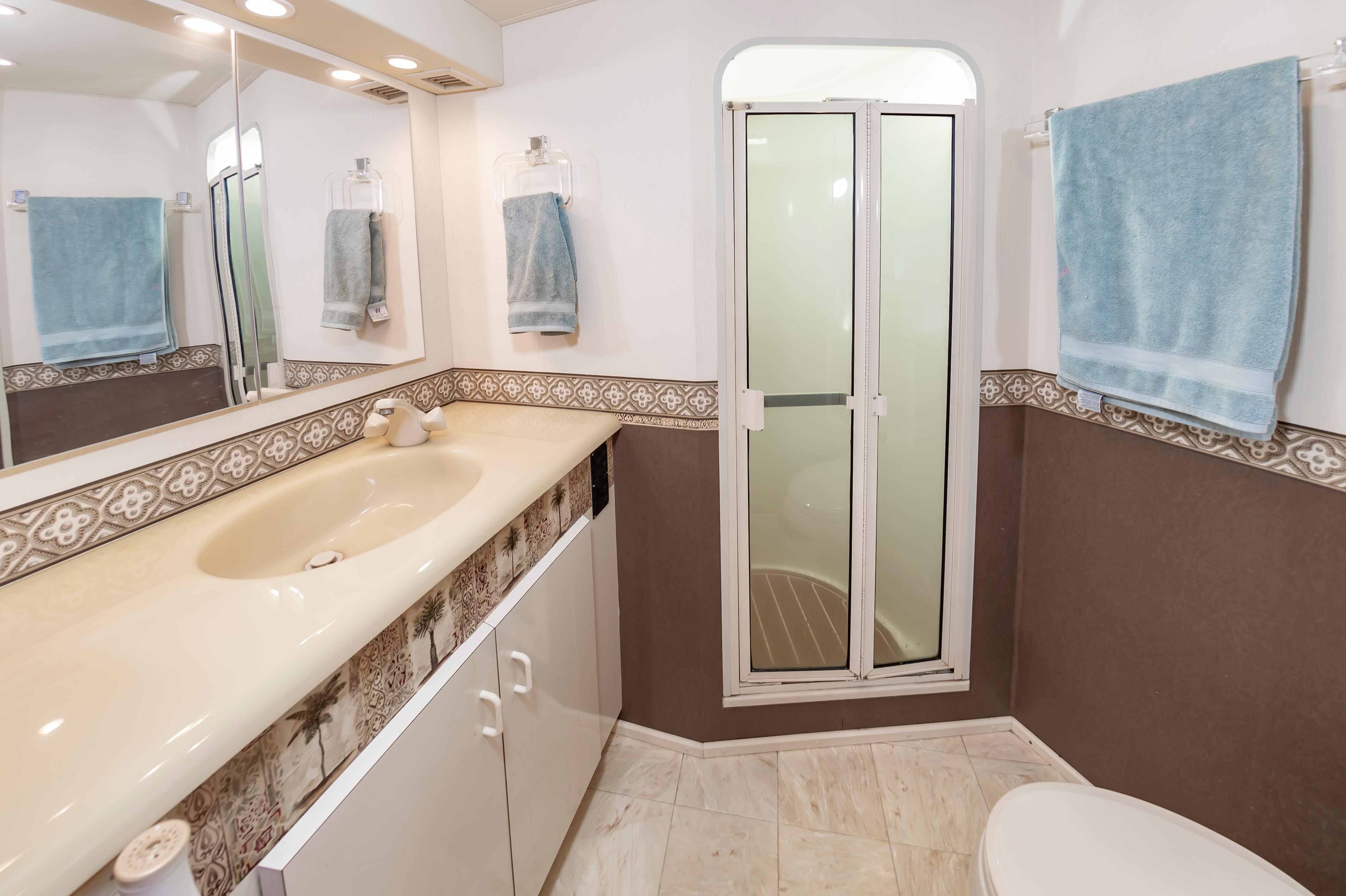 Slide: The Image of 1998 Viking Convertible bathroom with sink, mirror, shower, and blue towels. - 45