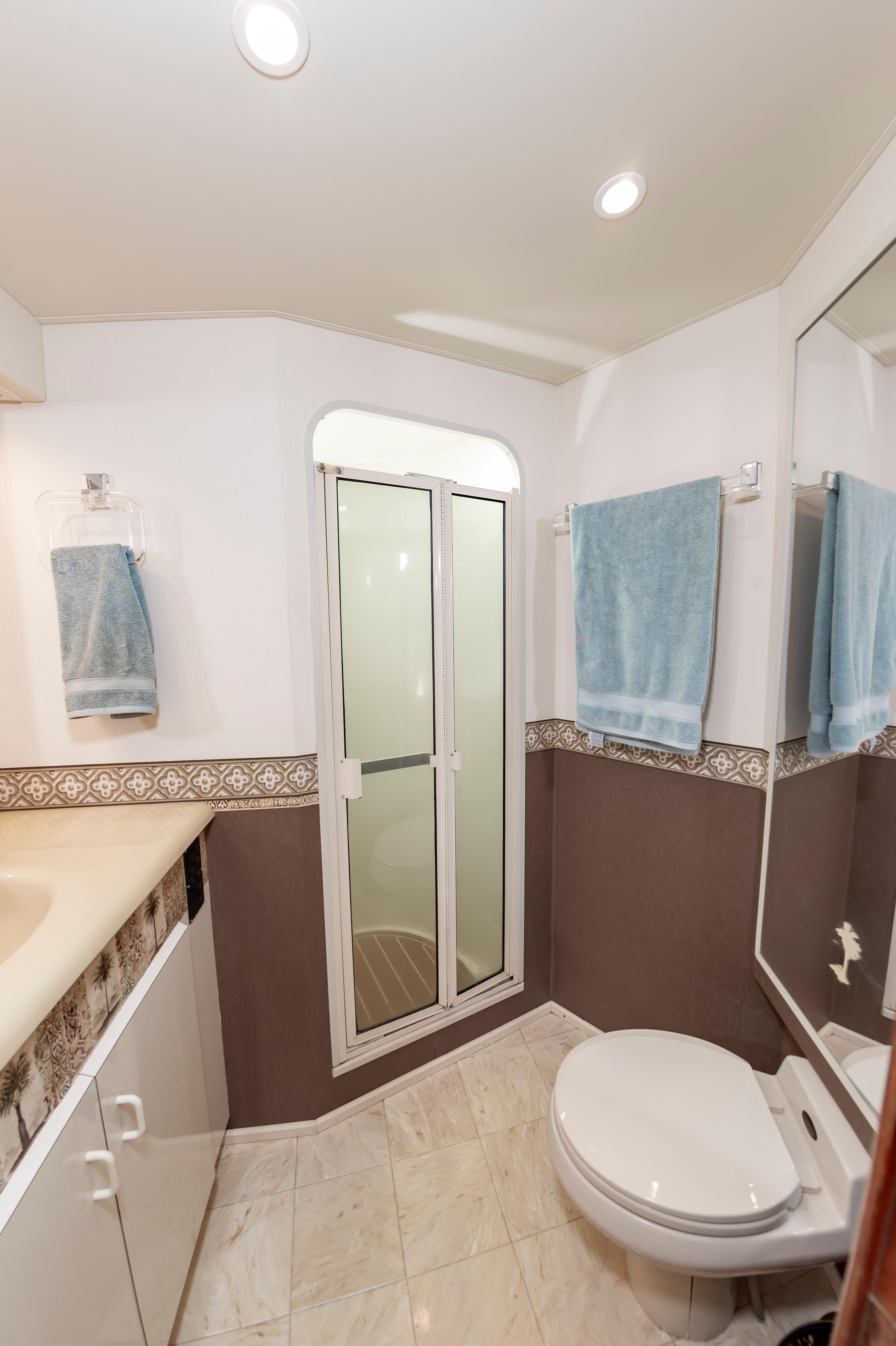 Slide: The Image of 1998 Viking Convertible bathroom with shower, toilet, sink, and blue towels. - 47
