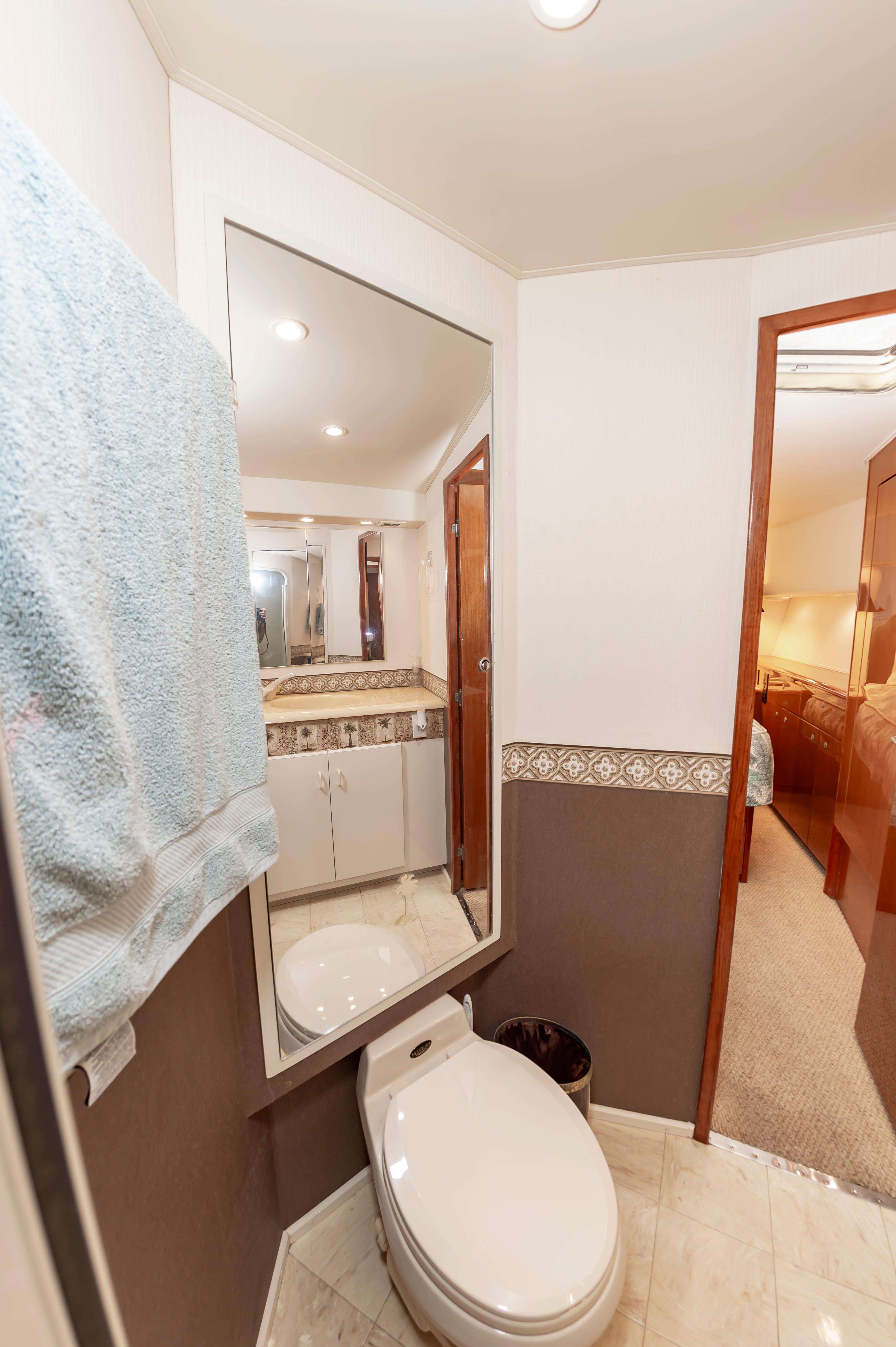 Slide: The Image of 1998 Viking Convertible yacht bathroom with toilet, mirror, and towel. - 48