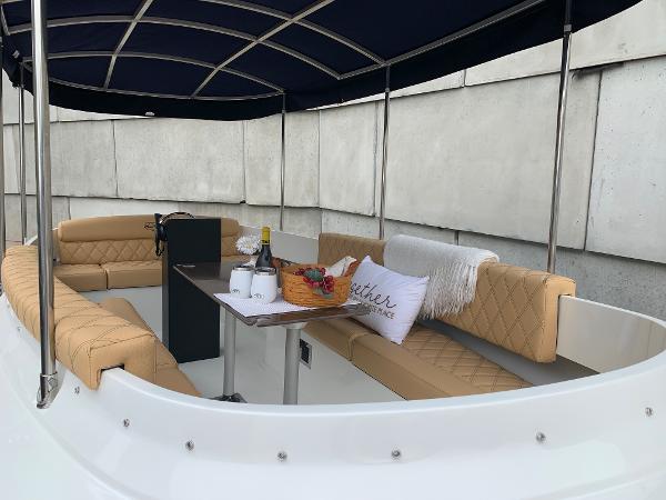 Slide: The Image of 2023 Vision Marine Technologies Fantail 217 boat with tan seating and a dining table. - 2