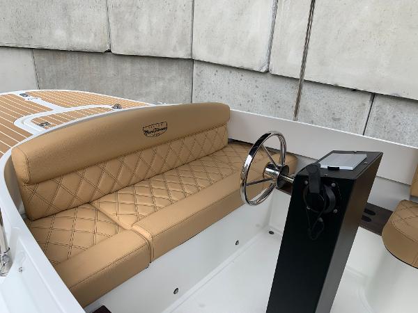 Slide: The Image of 2023 Vision Marine Technologies Fantail 217 boat interior with tan leather seating and steering wheel. - 7