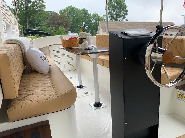 Slide: The Image of 2023 Vision Marine Technologies Fantail 217 interior with tan seating and steering wheel. - 8