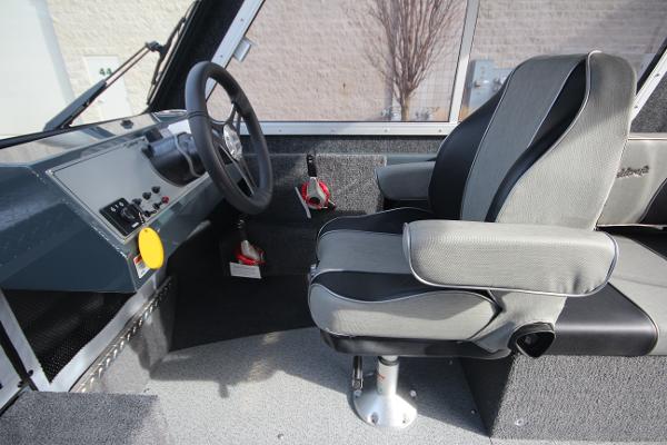 Slide: The Image of 2023 Weldcraft 210 Revolution F200XB boat interior with captain's chair and control panel. - 13
