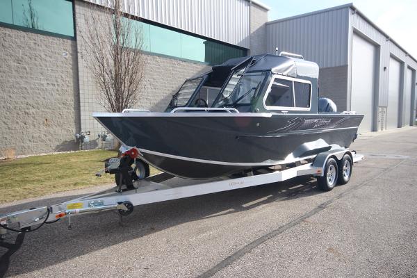 Slide: The Image of 2023 Weldcraft 210 Revolution F200XB boat on a trailer outside a warehouse. - 14