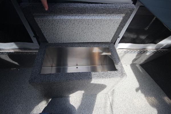 Slide: The Image of 2023 Weldcraft 210 Revolution F200XB storage compartment with open lid. - 27