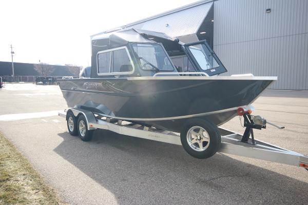 Slide: The Image of 2023 Weldcraft 210 Revolution F200XB boat on a trailer outside a warehouse. - 3