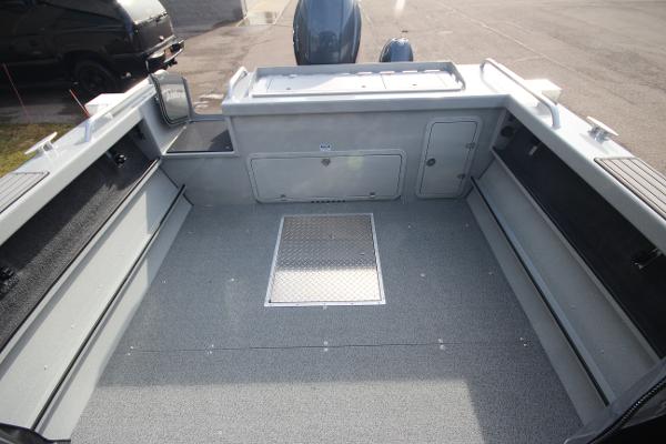 Slide: The Image of 2023 Weldcraft 210 Revolution F200XB boat interior, spacious deck, storage compartments. - 8