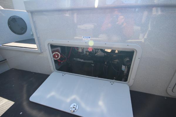 Slide: The Image of 2026 Weldcraft 220 Ocean King 250XB boat storage compartment with open hatch, revealing interior components. - 12