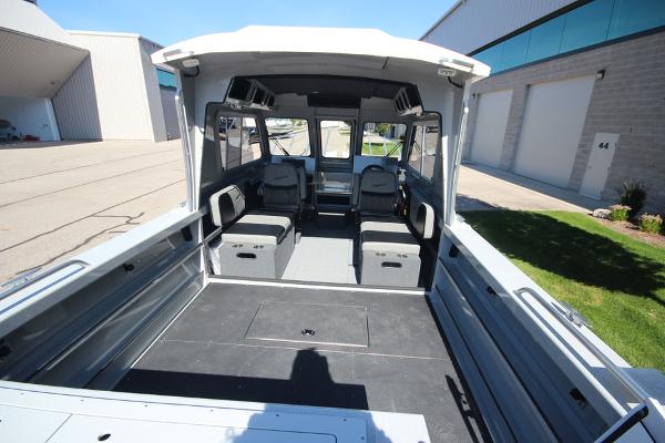 Slide: The Image of 2026 Weldcraft 220 Ocean King 250XB boat interior with seating and storage, docked outdoors. - 8