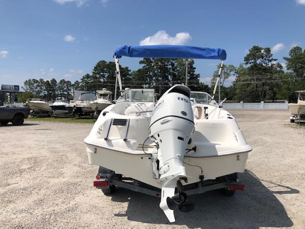 Slide: The Image of 2001 Wellcraft 180 Sportsman boat with outboard motor and blue canopy in a marina. - 1