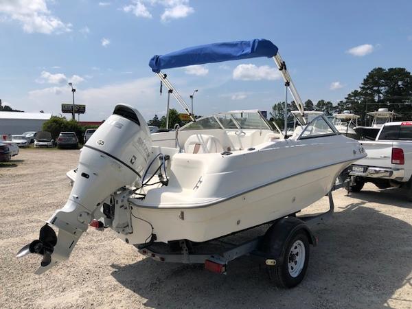 Slide: The Image of 2001 Wellcraft 180 Sportsman boat with blue canopy on trailer in parking lot. - 7